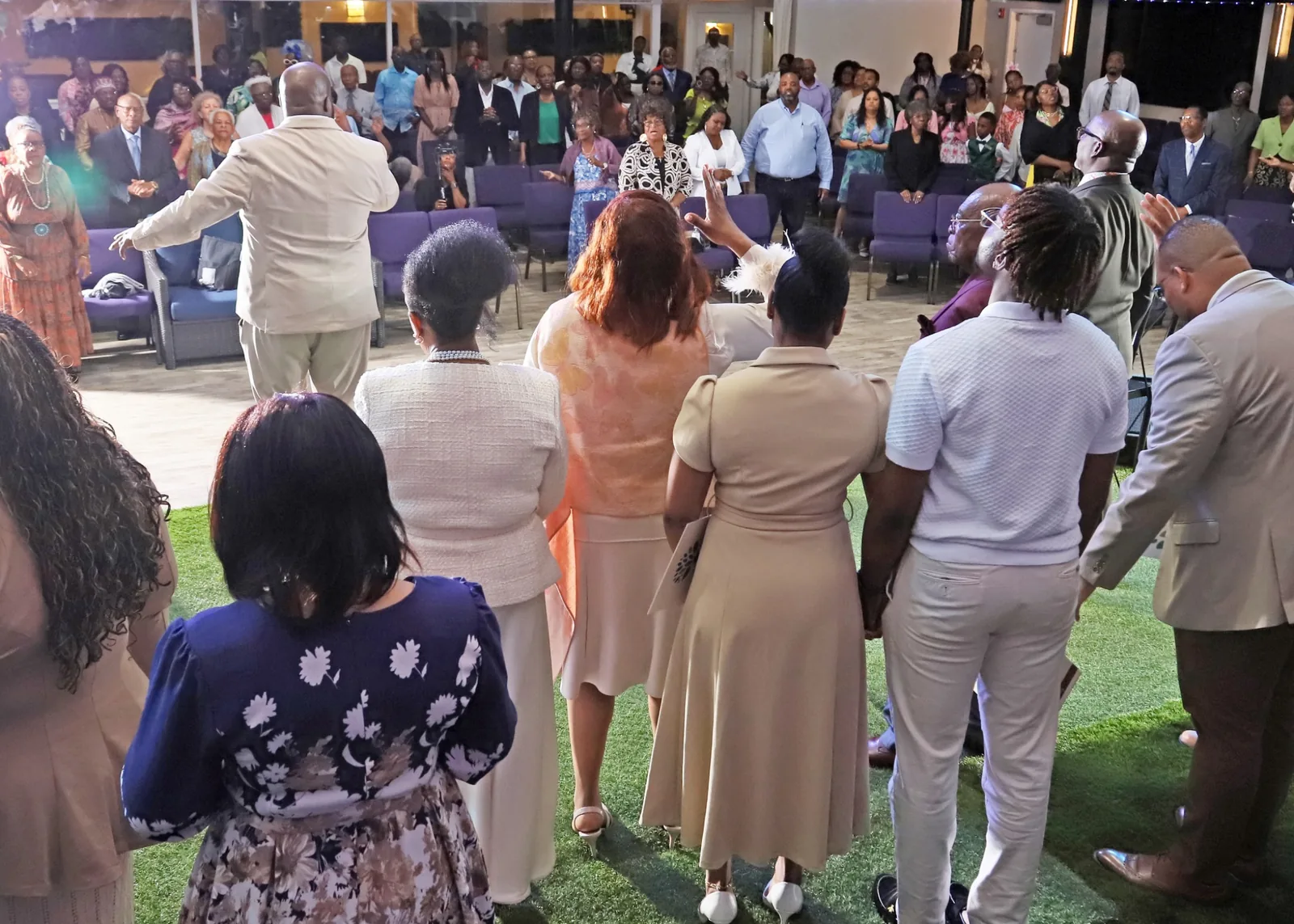 All Nations congregation praying together during worship